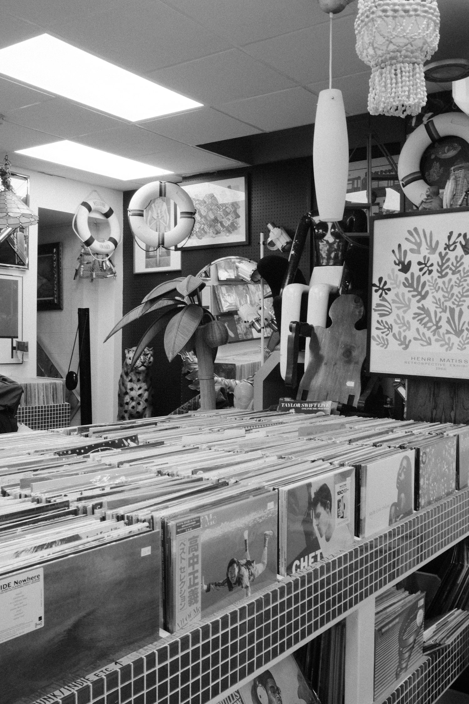 A record shop interior with full bins of LPs and hanging lamps